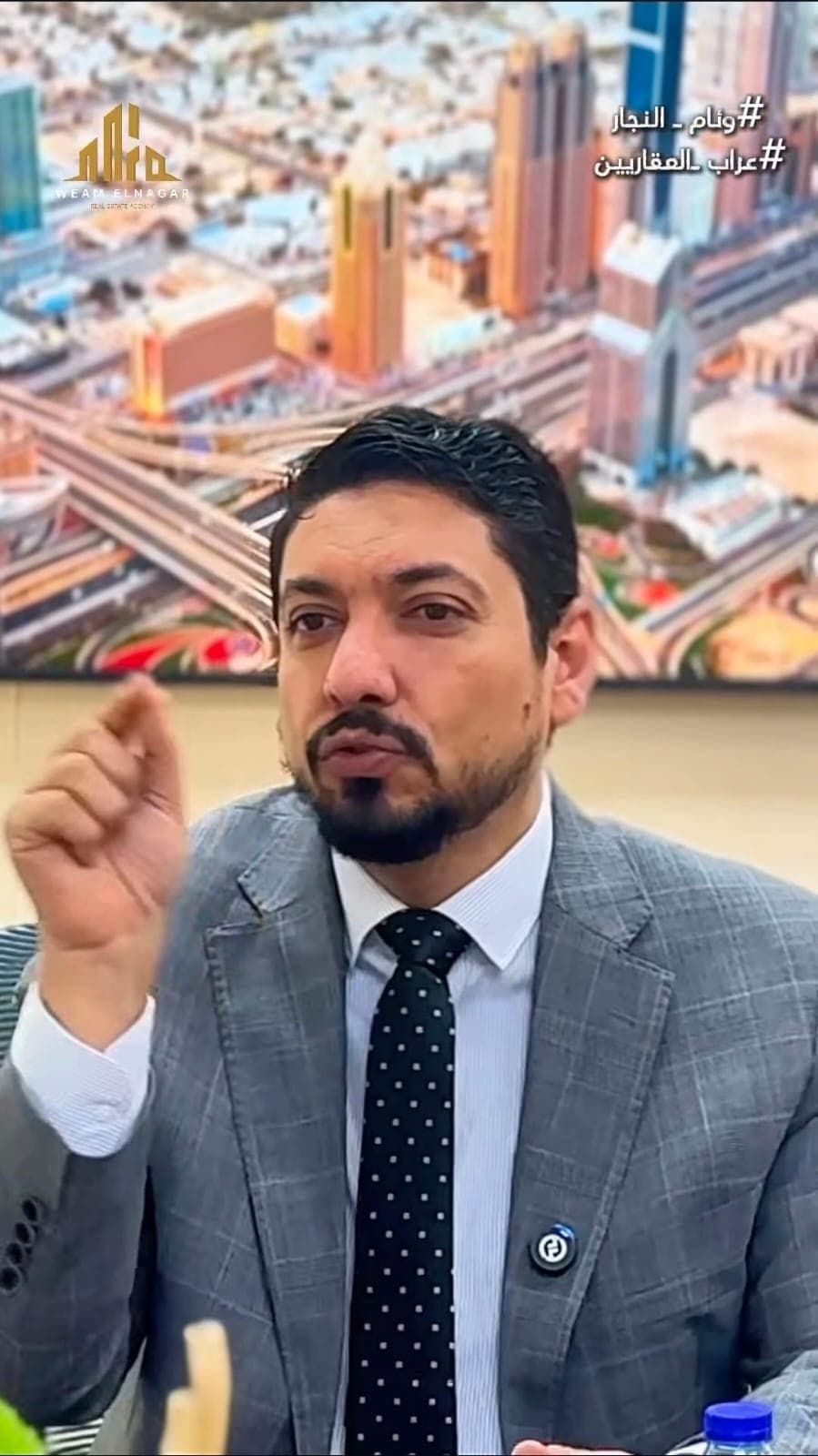 Weeam El Naggar making a point during a business interview, Dubai skyline backdrop